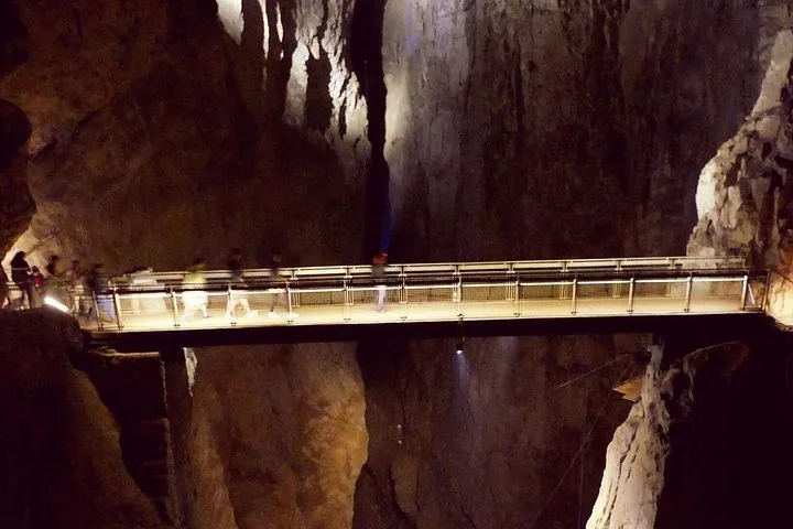 Bridge crossing a deep chasm inside an illuminated cave