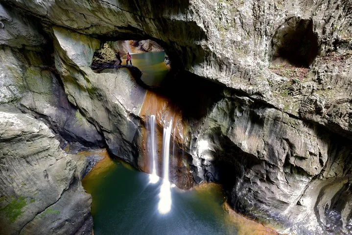 Underground river and waterfall flowing through a rocky cave